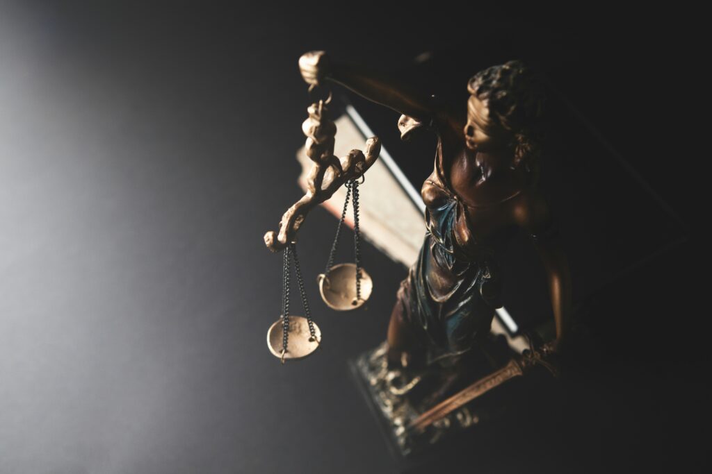 Can I sue someone in Kenya. An image of a woman idol holding the scales of justice