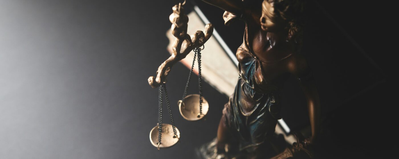 Can I sue someone in Kenya. An image of a woman idol holding the scales of justice